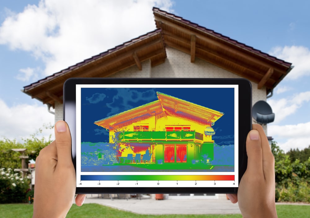 Close-up,Of,Person,Detecting,Heat,Loss,Outside,The,House,Using